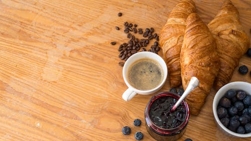 Cup of Coffee Beside Croissants and Blueberry Jam