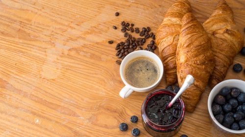 Free Enjoy a classic French breakfast with croissants, jam, blueberries, and coffee. Stock Photo