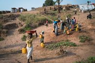 A group of villagers gathers water near Kalemie, DR Congo, showcasing daily rural life.
