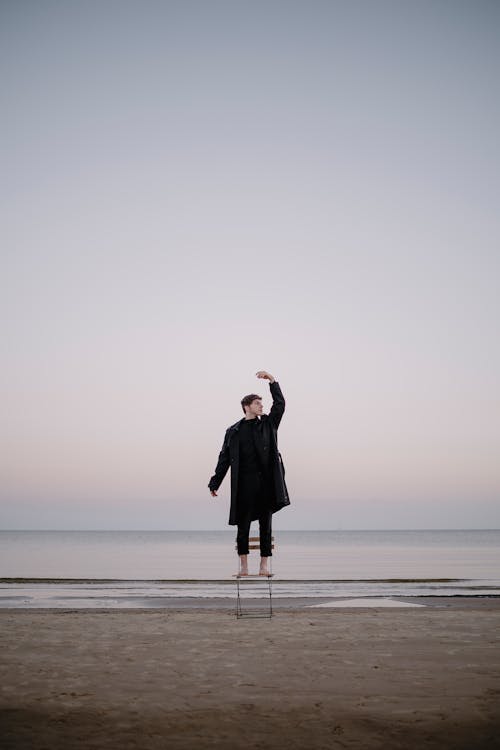 Man Standing on Chair on Beach