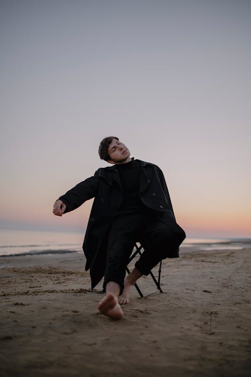 Man with Eyes Closed on Chair on Beach
