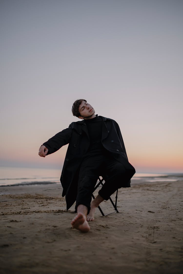 Man With Eyes Closed On Chair On Beach