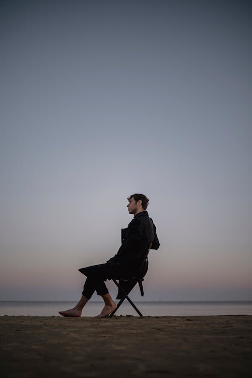 Man Sitting on a Chair on a Beach 