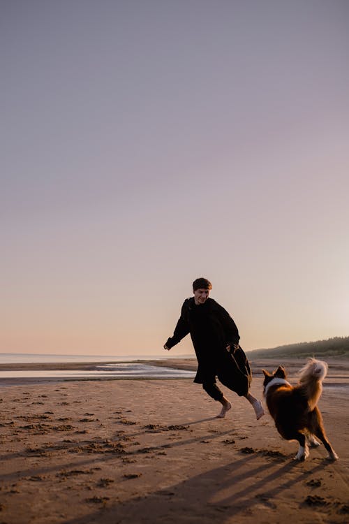 Man Playing with his Dog on the Beach 