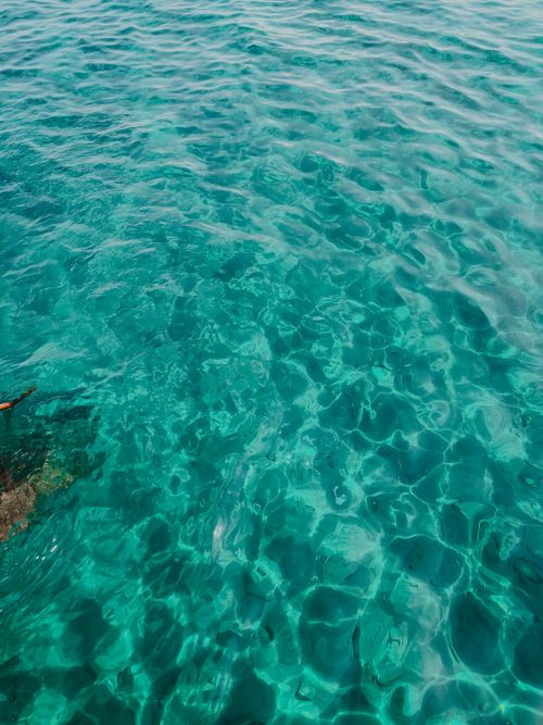 Free Vibrant turquoise water with sunlit ripples creating a serene oceanic view. Stock Photo