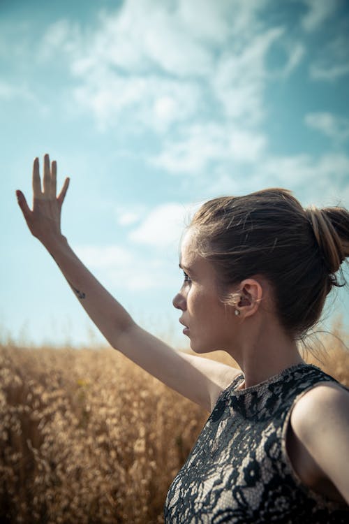 A Woman Standing on Brown Field