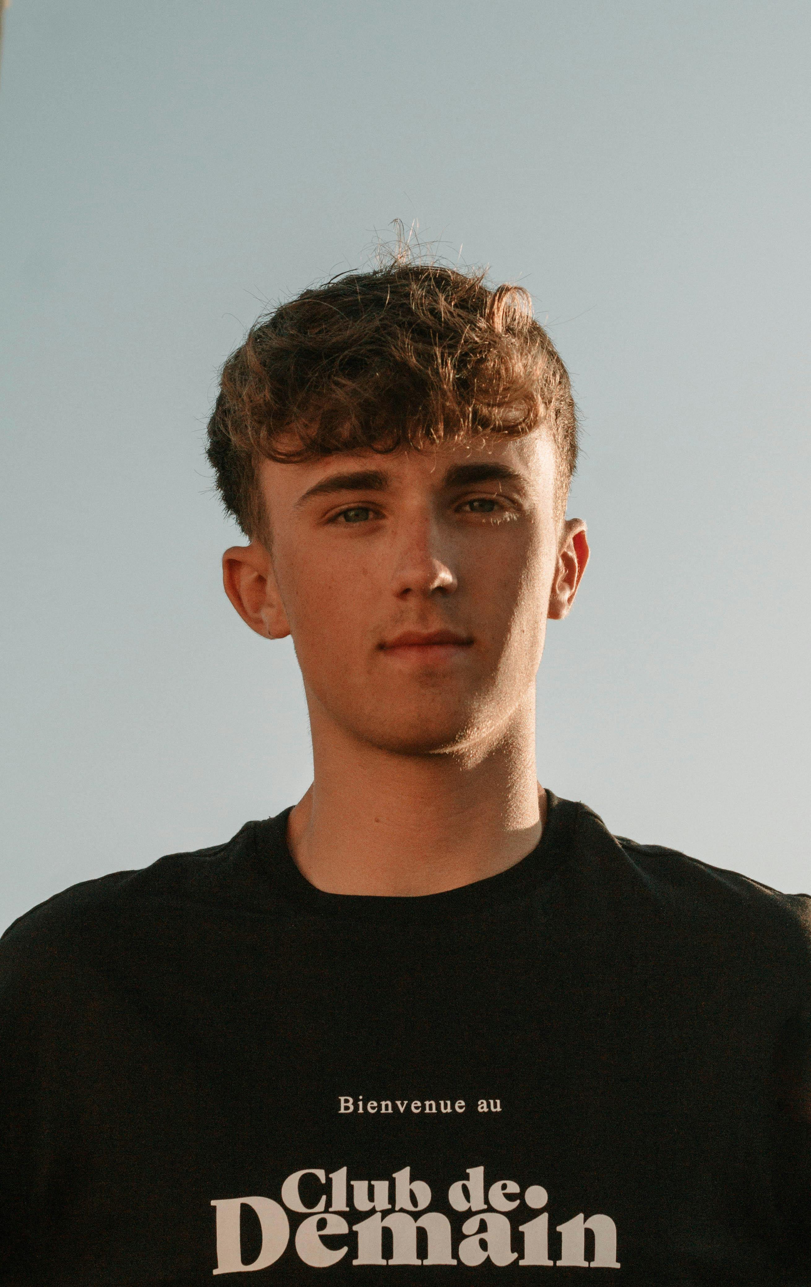 Close-up portrait of a young man in a black shirt in Mijas, Spain, during a sunny day.