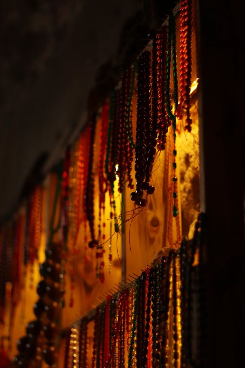 Free Vibrant bead necklaces hanging under warm light in Kayseri market. Stock Photo