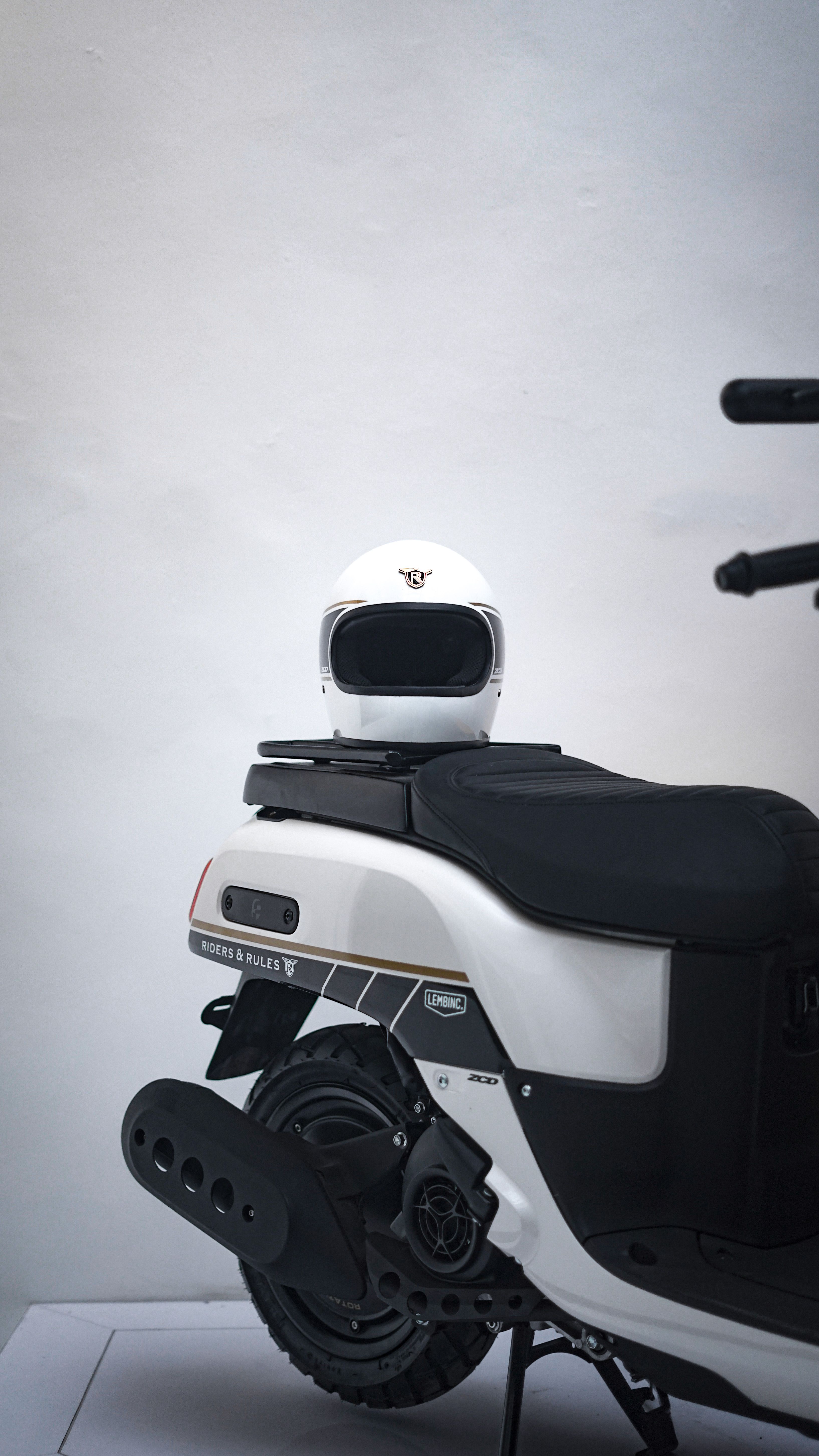 Close-up of a white helmet on a modern electric scooter with a minimalistic background.
