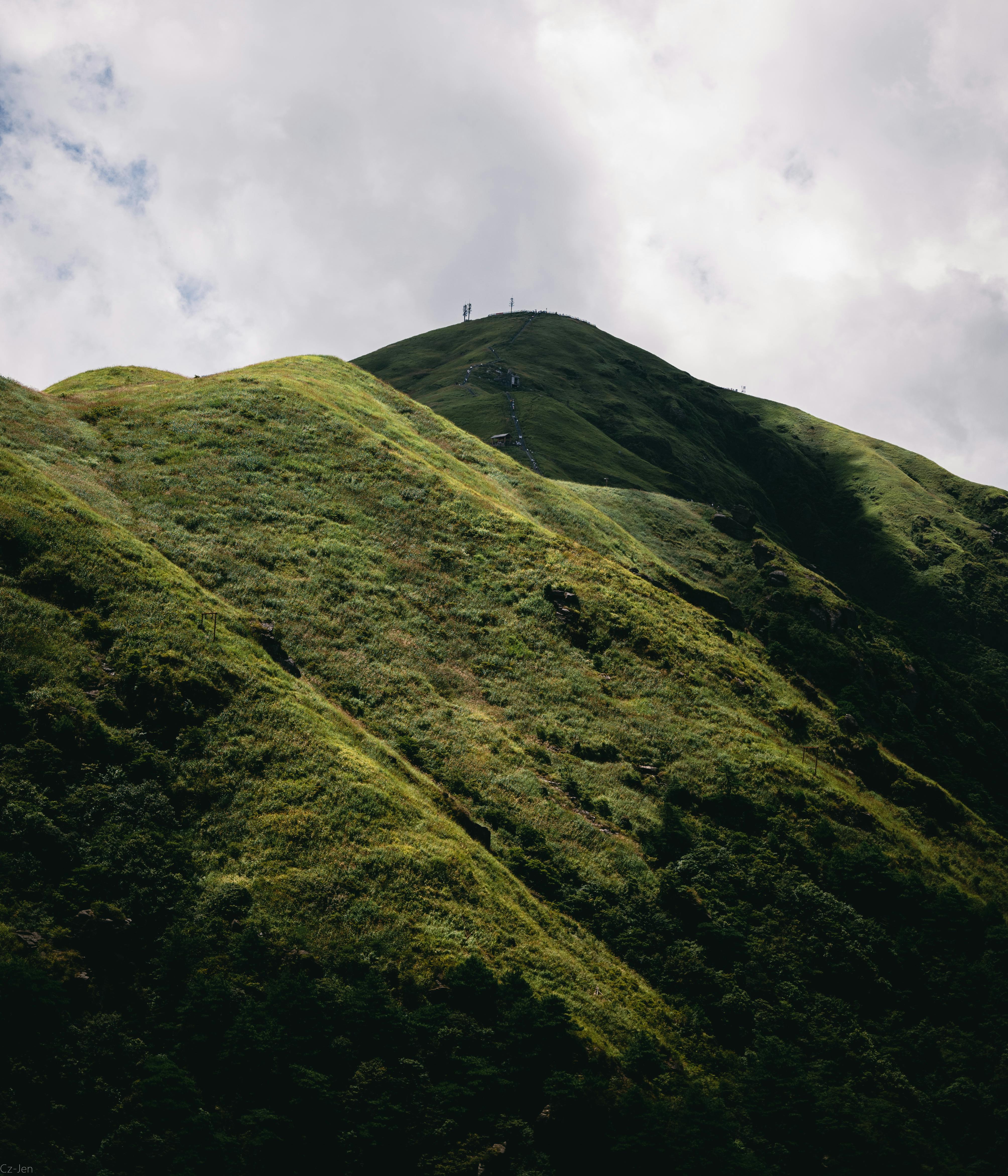 A scenic view of lush green hills under a cloudy sky, perfect for nature lovers.