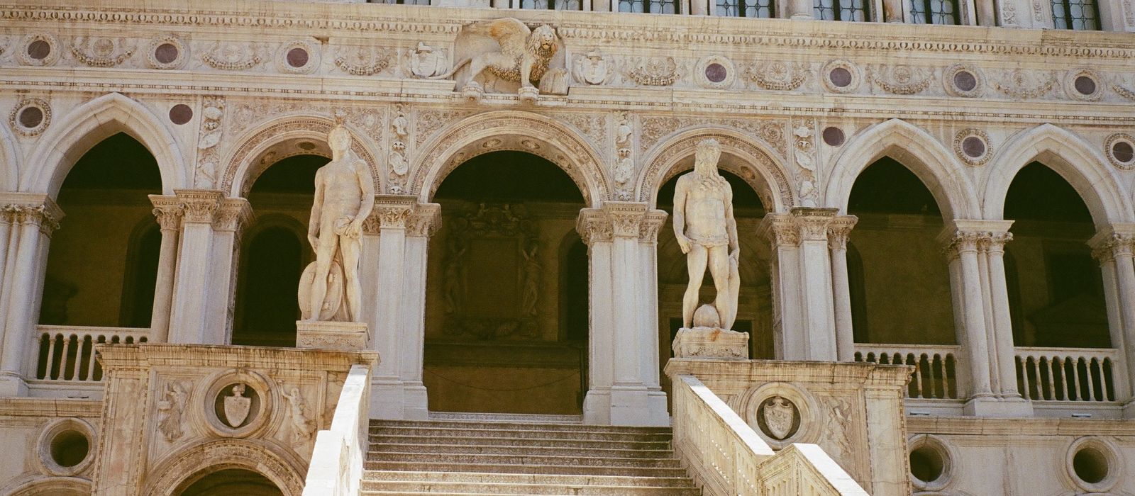 Explore the grandeur of Doge's Palace with its iconic arches and staircases in Venice, Italy.