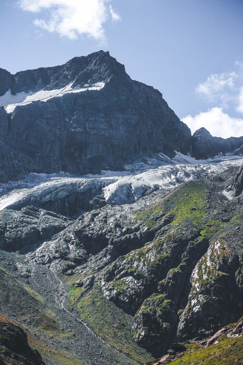 Free Stunning aerial view of a rocky mountain landscape with lush greenery and clear blue sky. Stock Photo