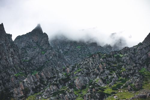 Free Dramatic rocky mountain peaks shrouded in misty clouds, showcasing nature's grandeur. Stock Photo