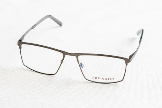 Close-up of stylish Freigeist eyeglasses on white surface, minimalist style.