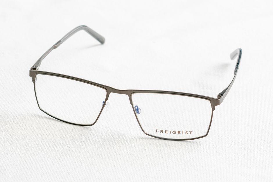 Close-up of stylish Freigeist eyeglasses on white surface, minimalist style.