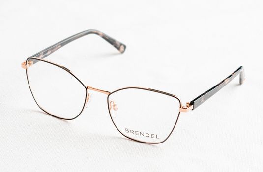 Close-up of stylish gold eyeglasses with 'BRENDEL' branding on a clean white surface.