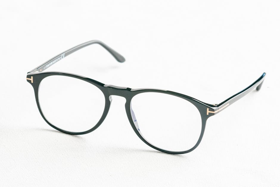 Minimalist close-up of fashionable black eyeglasses on a white surface.