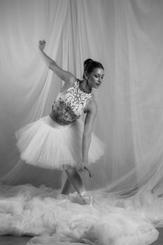 Graceful ballerina performing in a monochrome setting.