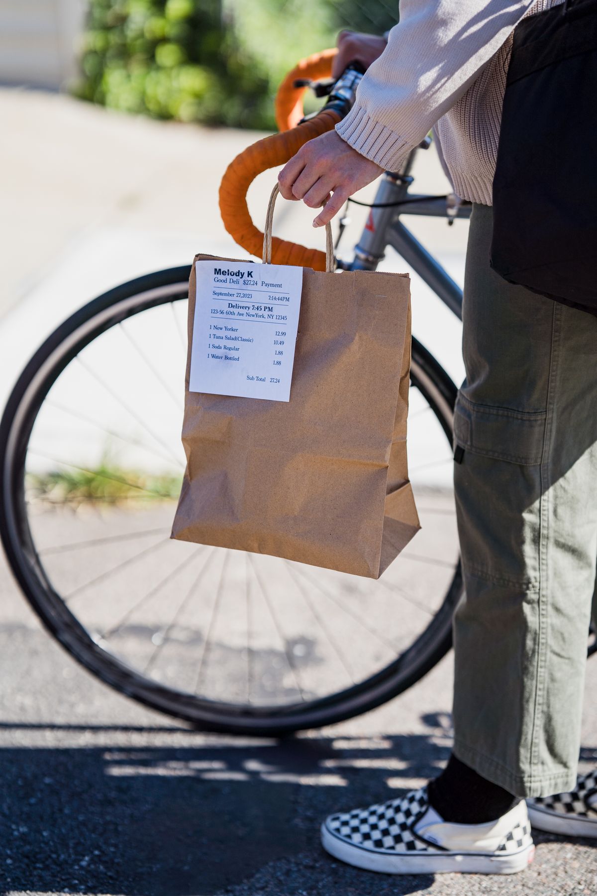 Cyclist standing beside a bicycle while holding a parcel