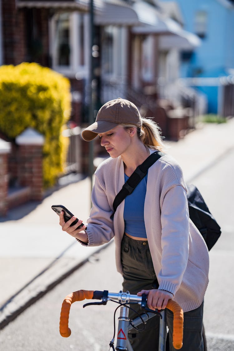 Girl On Bike Looking At Mobile Phone