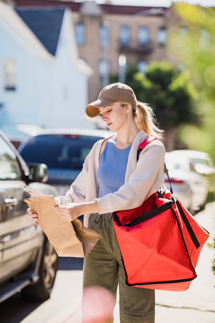 Delivery Girl Reading Notes On Paper Bag