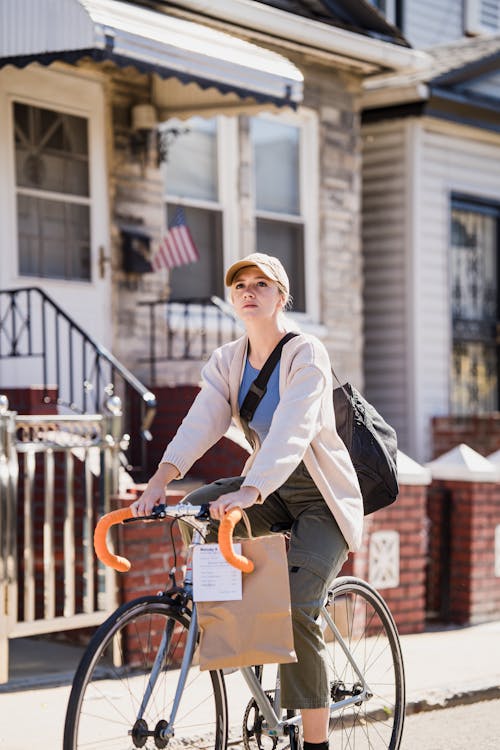 Young Woman on Bike Delivering Food in Paper Bag