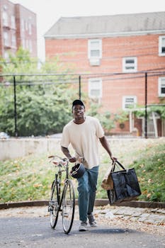 Young man delivering food on bicycle in city environment, smiling and active.