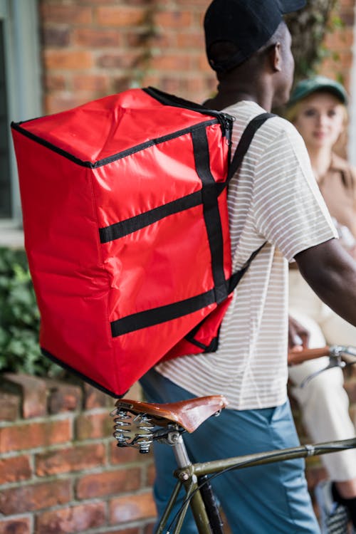 Close-up of Courier with Backpack on Bike