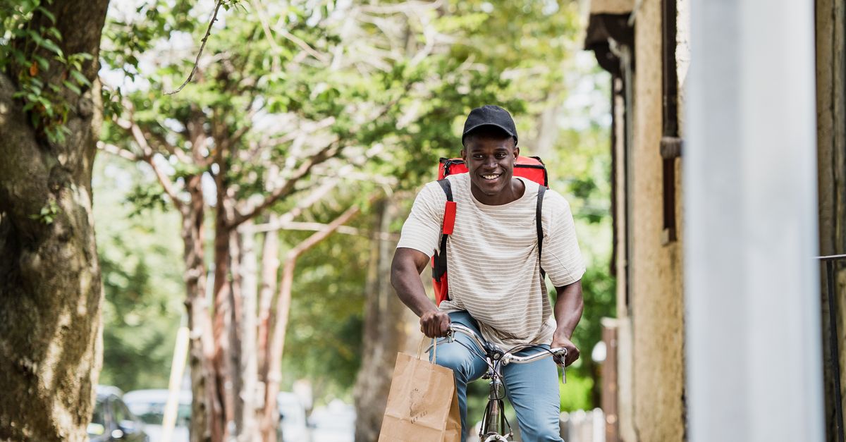 Courier Riding Smiling Courier Riding Bike Delivering Order · Free Stock Photo