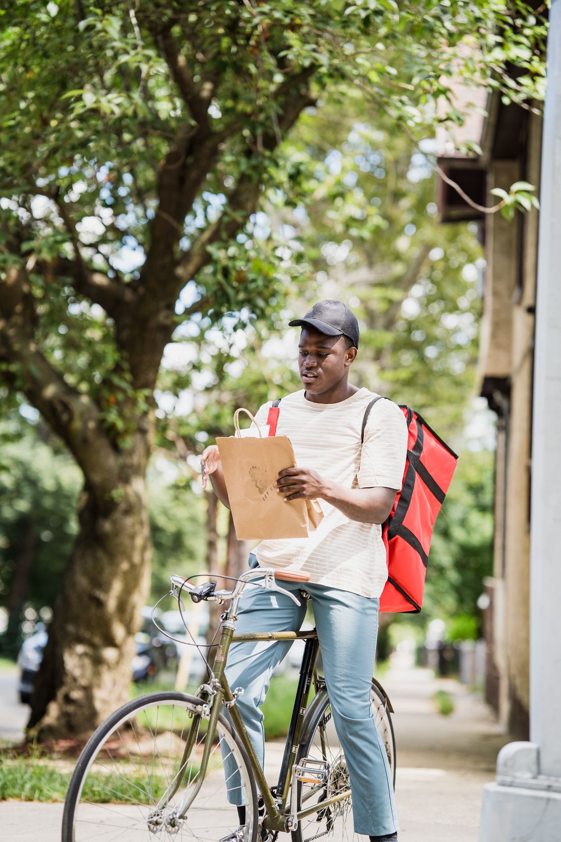 Urban bicycle courier carrying a delivery backpack while riding along a city route