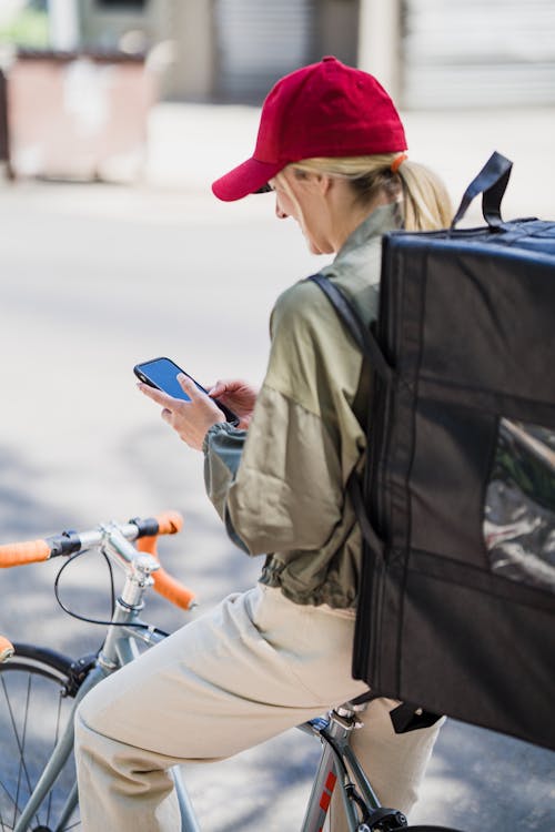 Courier with Backpack Using Cellphone