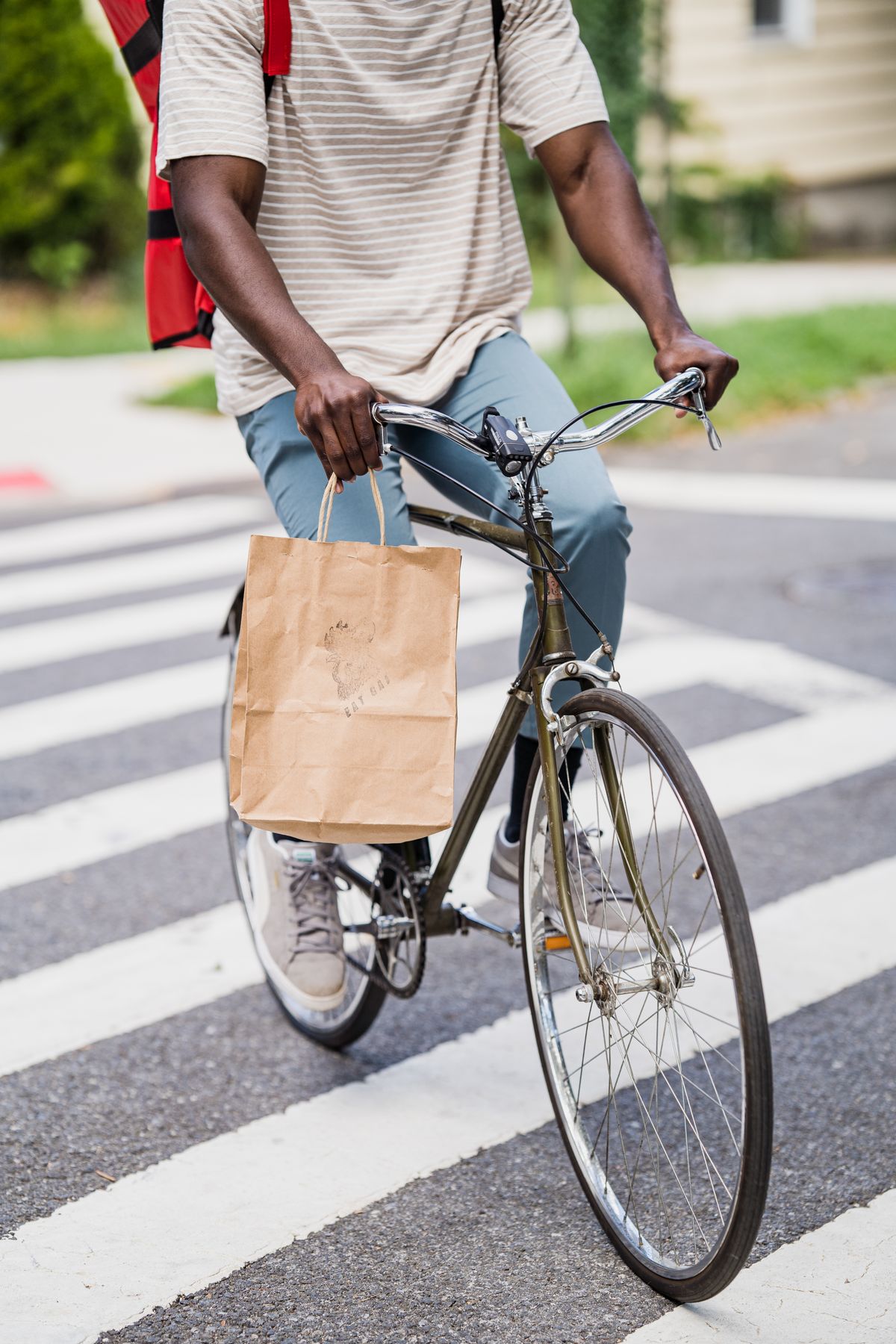 Bicycle courier crossing a city street while transporting an order