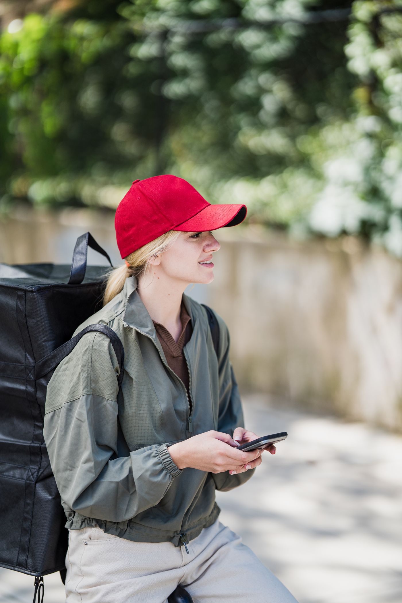 Courier checking delivery information on a smartphone