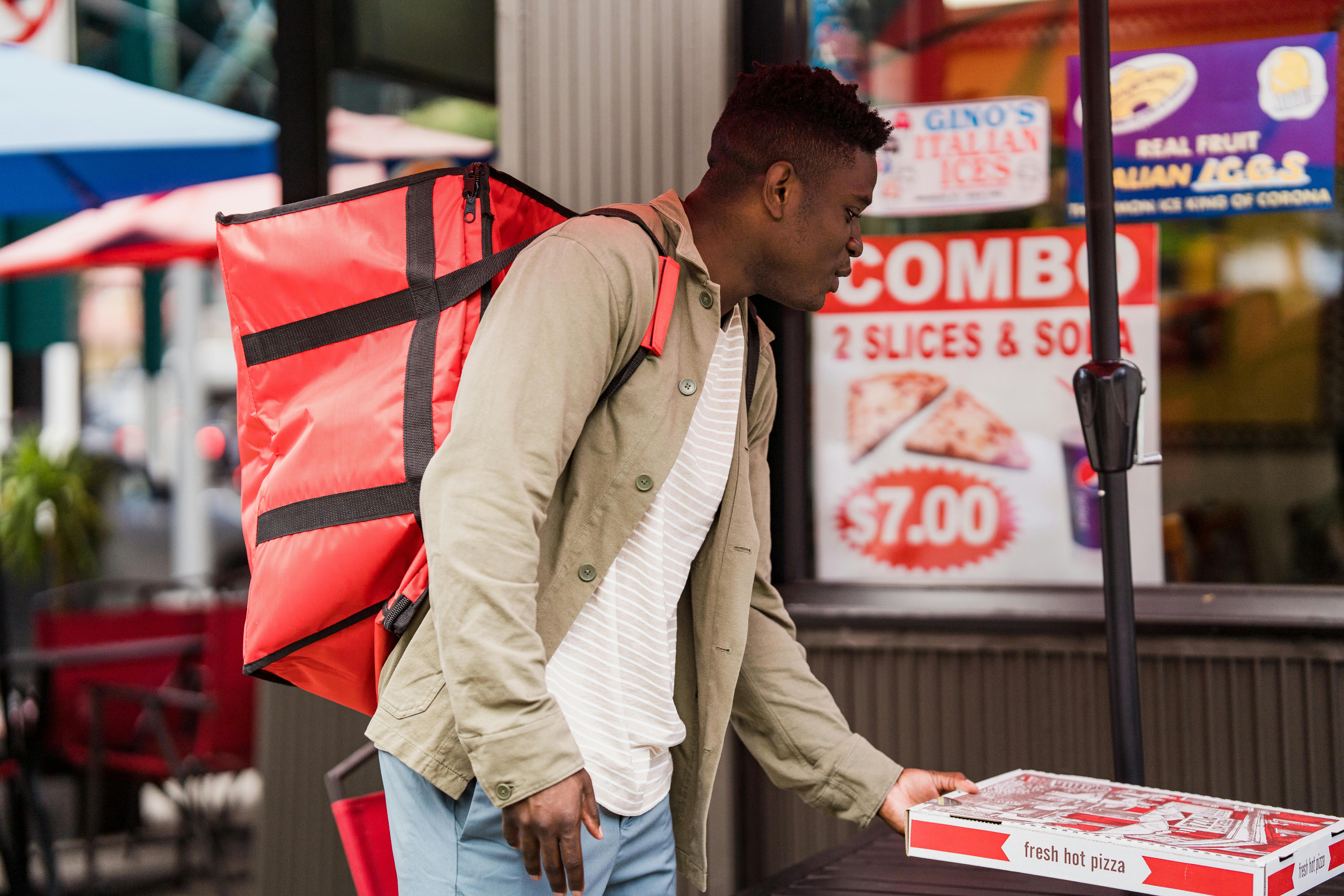 food delivery courier picking up a sealed bag from a ghost kitchen window - Seattle commercial kitchen