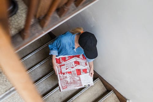Woman with Pizza Climbing the Stairs