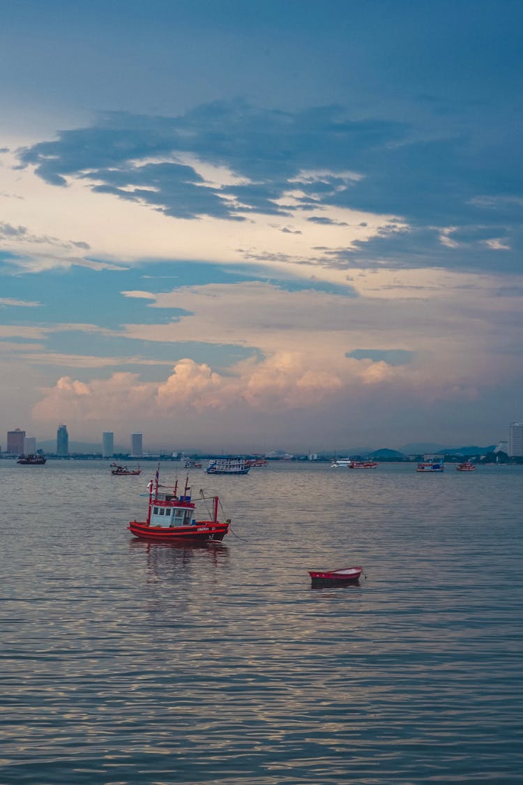 Fishing Boat On The Sea And City Skyline In The Background 