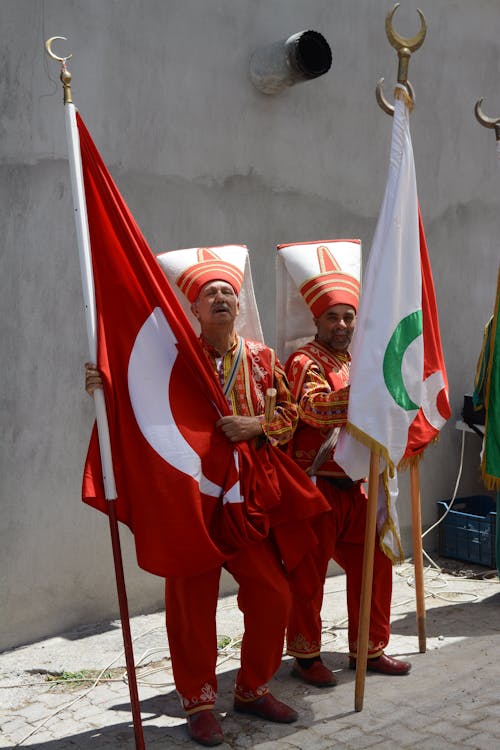 Men in Traditional Turkish Clothing Holding Flags 