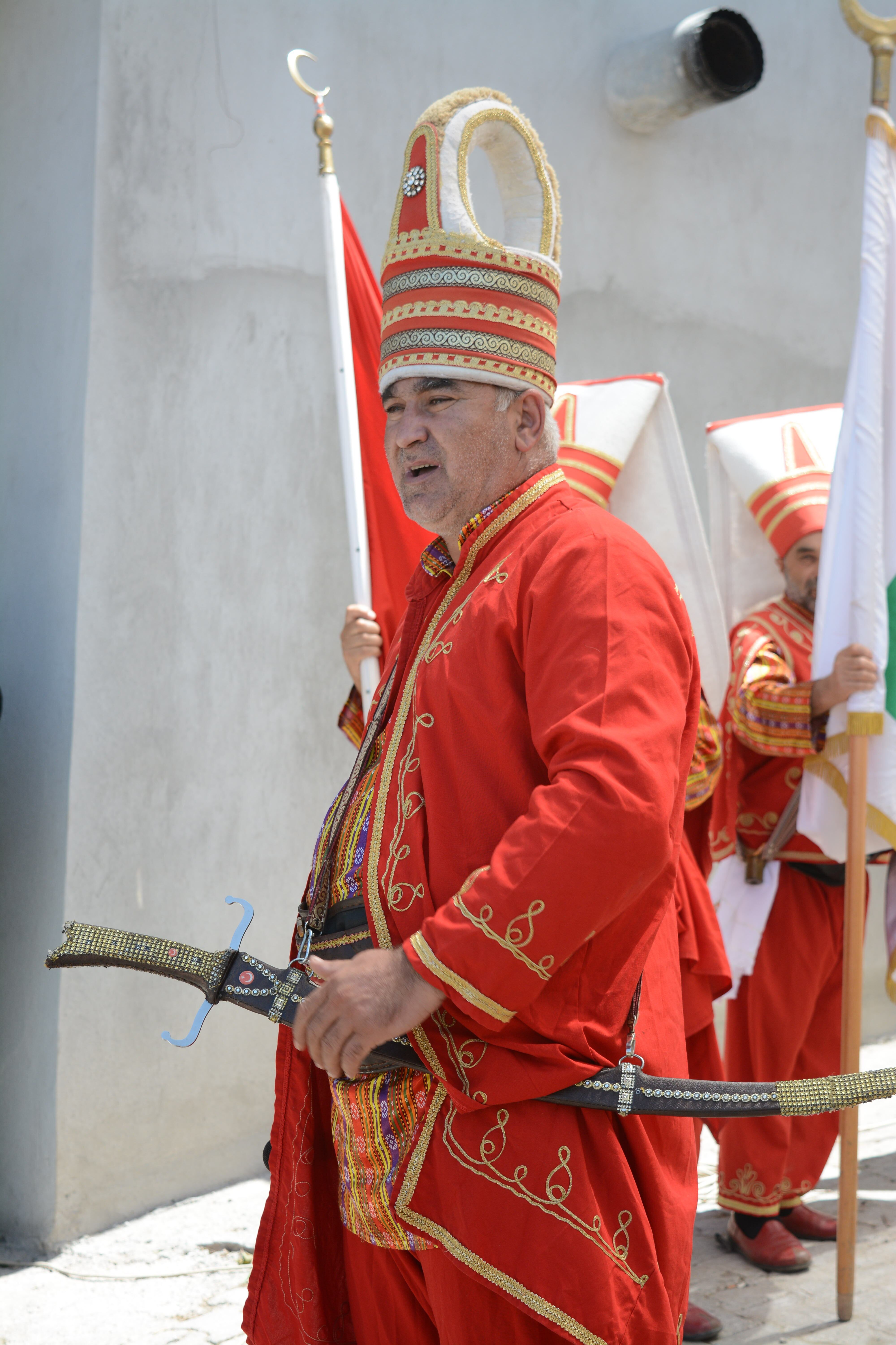 Men in traditional Ottoman costumes with swords participate in a cultural parade in Yenice, Türkiye.
