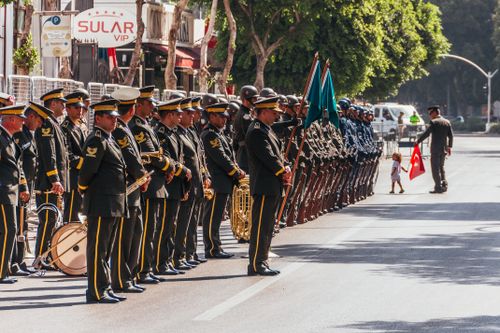 Free Uniformed soldiers in a ceremonial parade with Turkish flag on a city street. Stock Photo