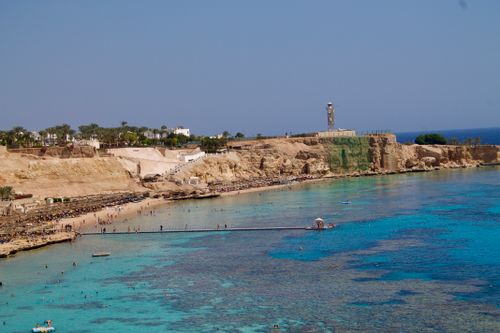 Free A beautiful Egyptian beach landscape with clear blue waters and a lighthouse on the coast. Stock Photo