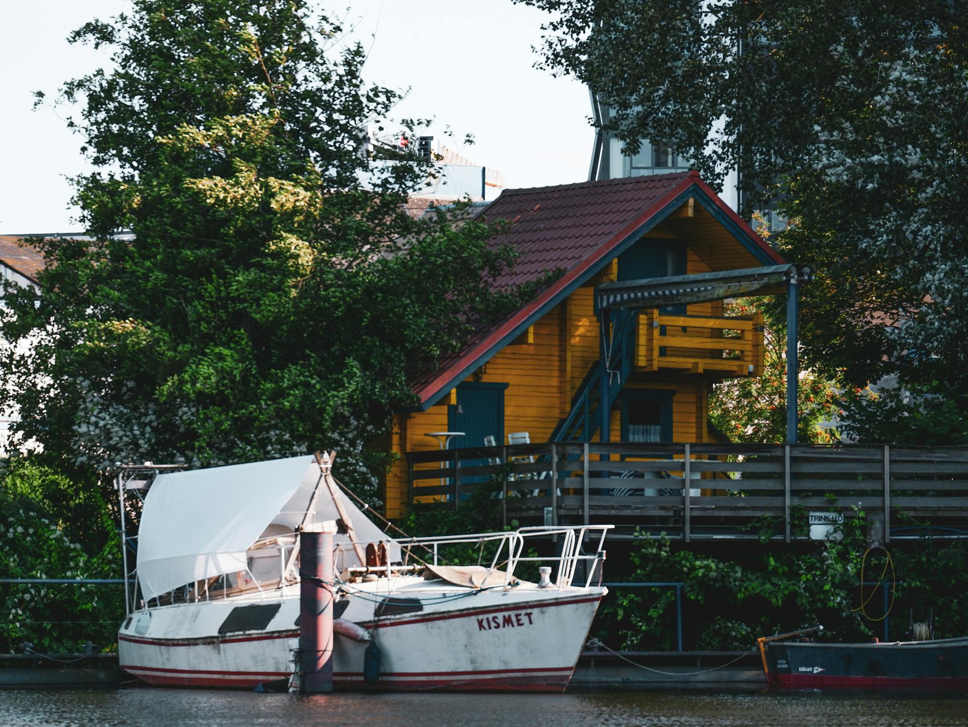 Charming wooden house and docked boat on a peaceful waterway in Hamburg.