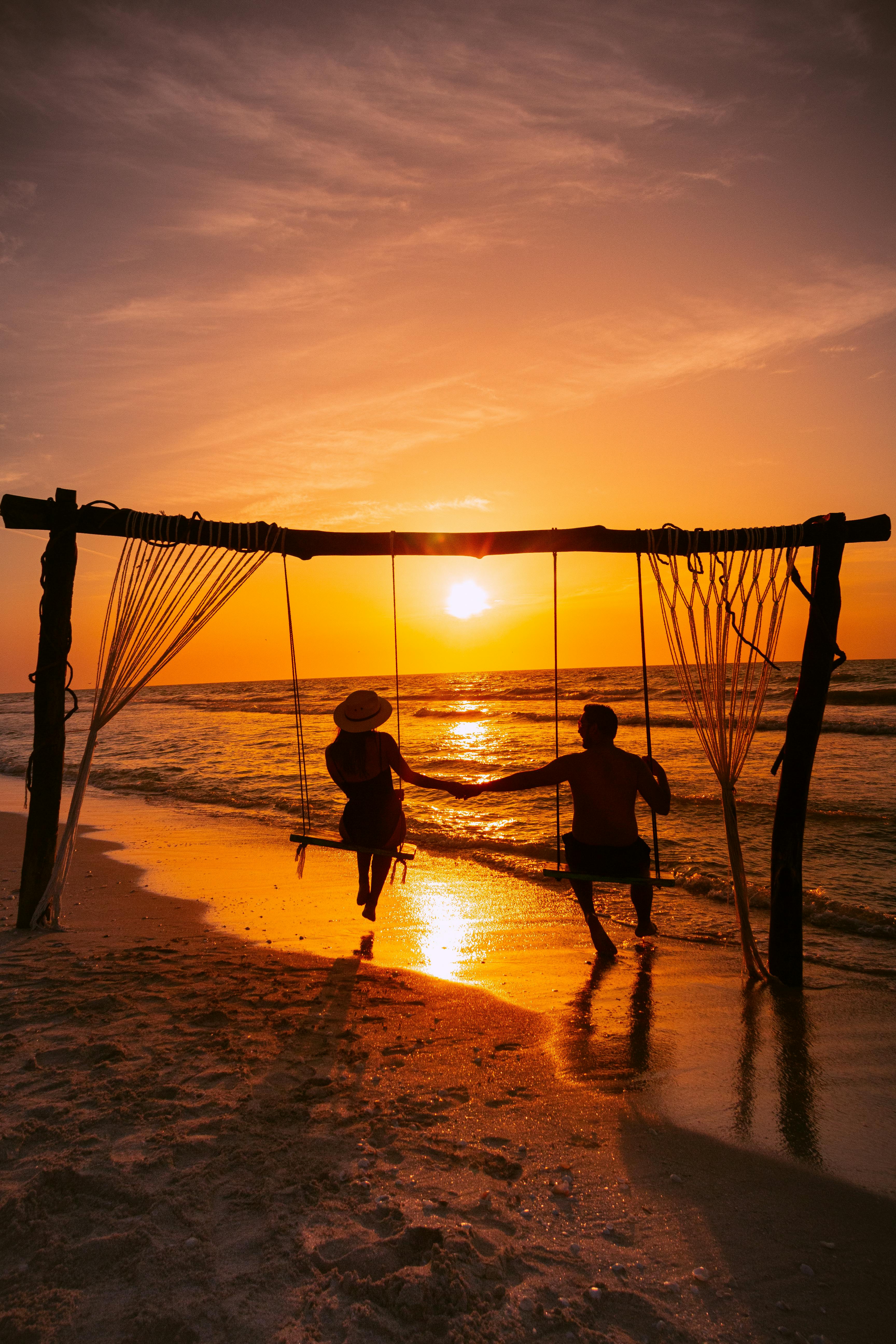 A Couple on Swings at the Beach · Free Stock Photo