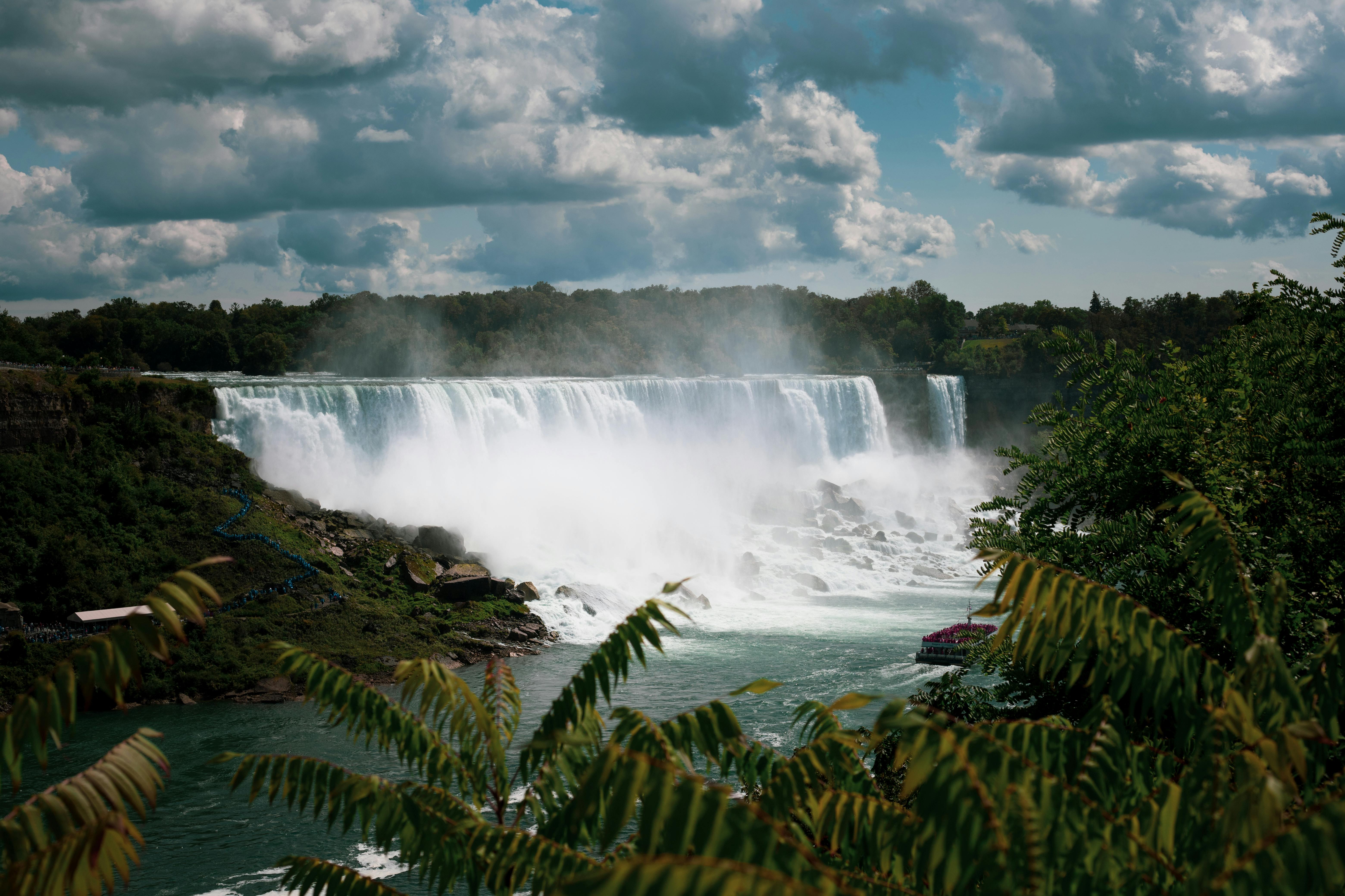 Beautiful summer view of Niagara Falls, Ontario, capturing the cascading water and lush greenery.
