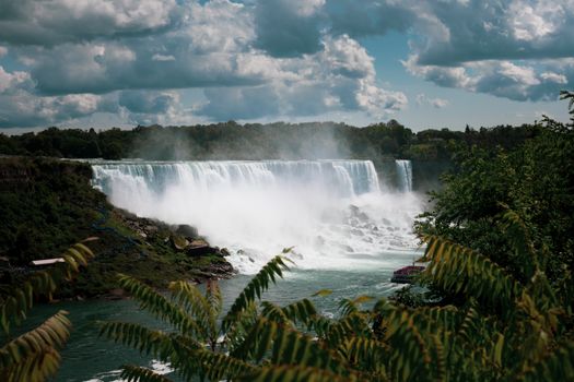 Beautiful summer view of Niagara Falls, Ontario, capturing the cascading water and lush greenery.