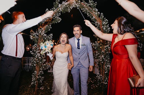 Wedding Guests Holding Sparklers over the Bride and Groom 