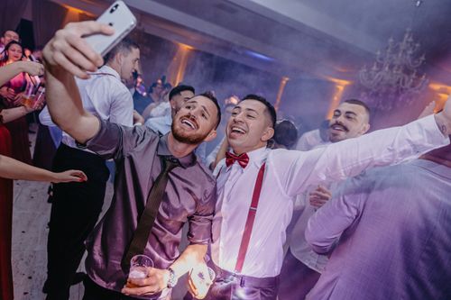 Free Group of friends enjoying a lively party, capturing the moment with a smartphone selfie. Stock Photo