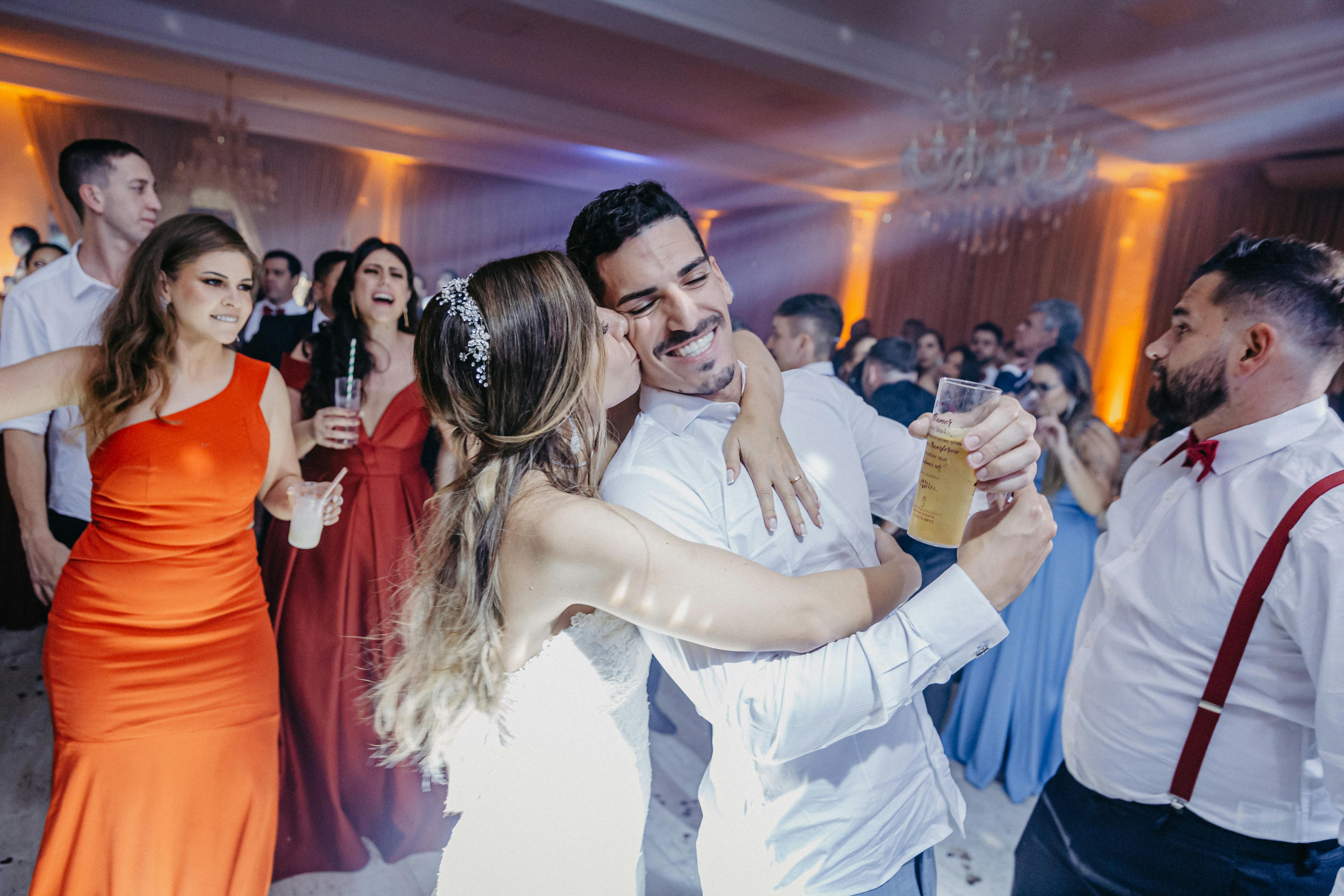 A cheerful moment captured during a lively wedding celebration with a dancing couple and guests.