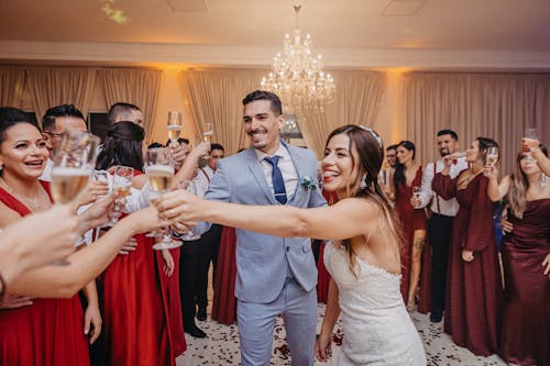 Bride and Groom Clinking Glasses of Champagne with the Guests 