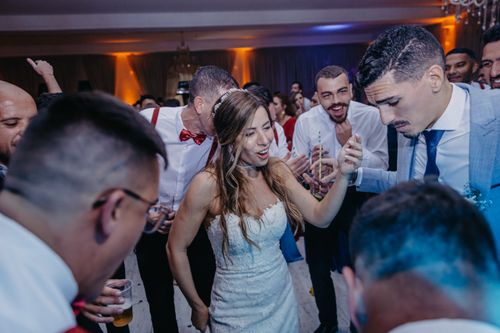 Free A vibrant scene of newlyweds dancing with guests at their wedding reception, full of joy and celebration. Stock Photo