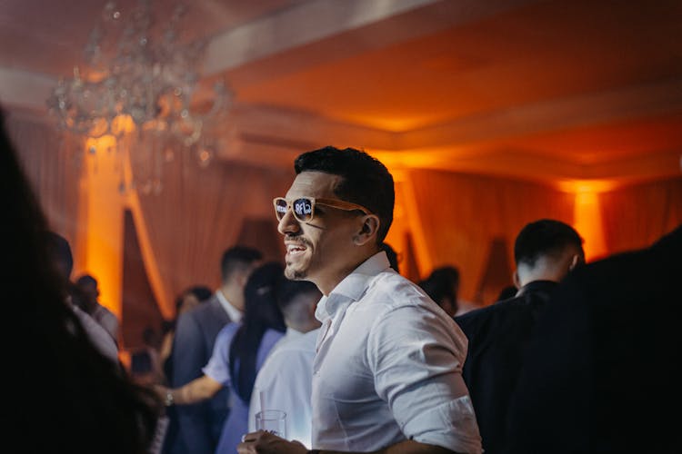 A Man Wearing Sunglasses At A Party